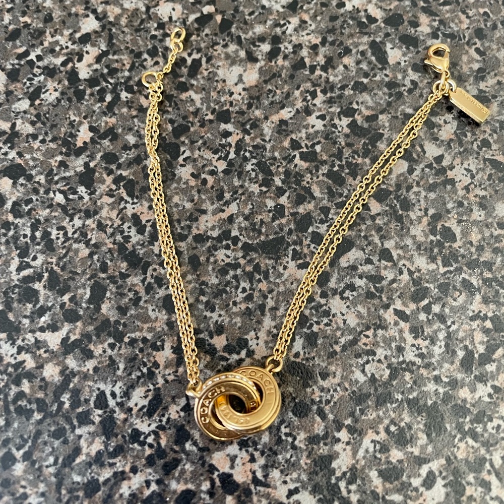 NWOT Beautiful Coach gold and crystal bracelet. Never worn. GRAB IT LADIES..!!
